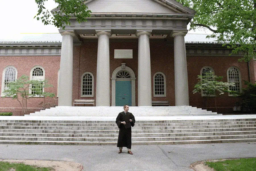 Dylan Randle in graduation robes outside Harvard's Memorial Hall
